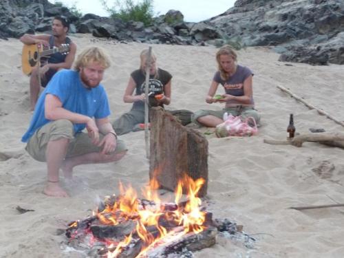 mannen houden zich met het vuur bezig terwijl de vrouwtjes het eten klaar maken